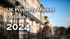 A couple holding their hands and walking in front of a UK property representing the market outlook for 2024